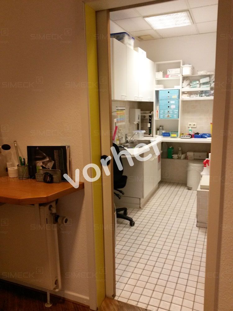 Eine Tür, die zu einer Küche mit weißen Fliesenböden und weißen Schränken führt.