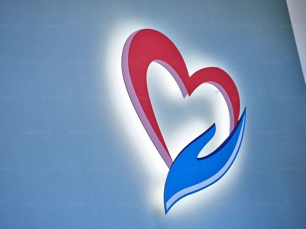 Ein blau-rotes Herz, das von zwei Händen gehalten wird