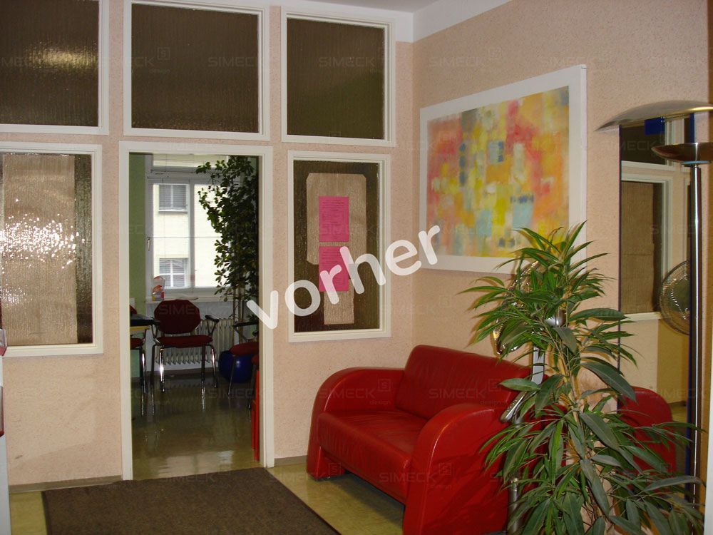 Eine rote Couch in einem Zimmer mit dem Wort „Vorher“ an der Wand