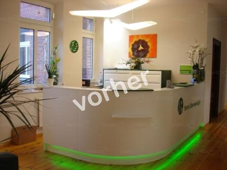 Ein weißer Rezeptionstresen mit grünen Lichtern und dem Wort „Vorher“ darauf