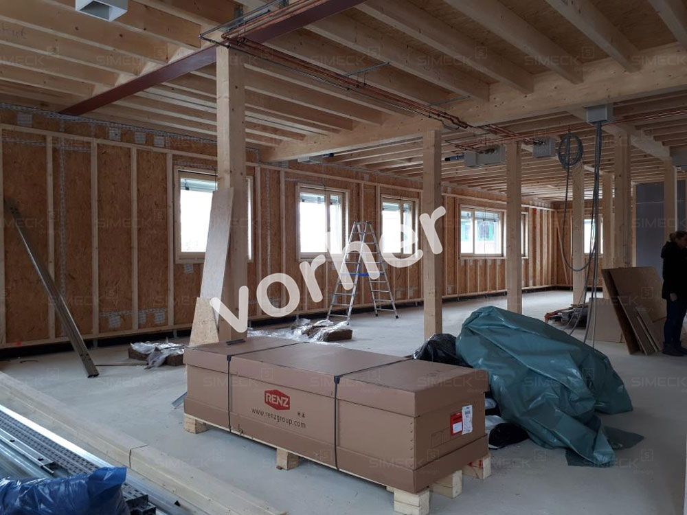 Ein großer Raum mit vielen Holzbalken und Kisten auf dem Boden.