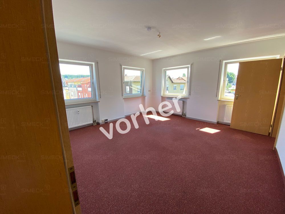 Ein leerer Raum mit einem roten Teppich und einer Tür.