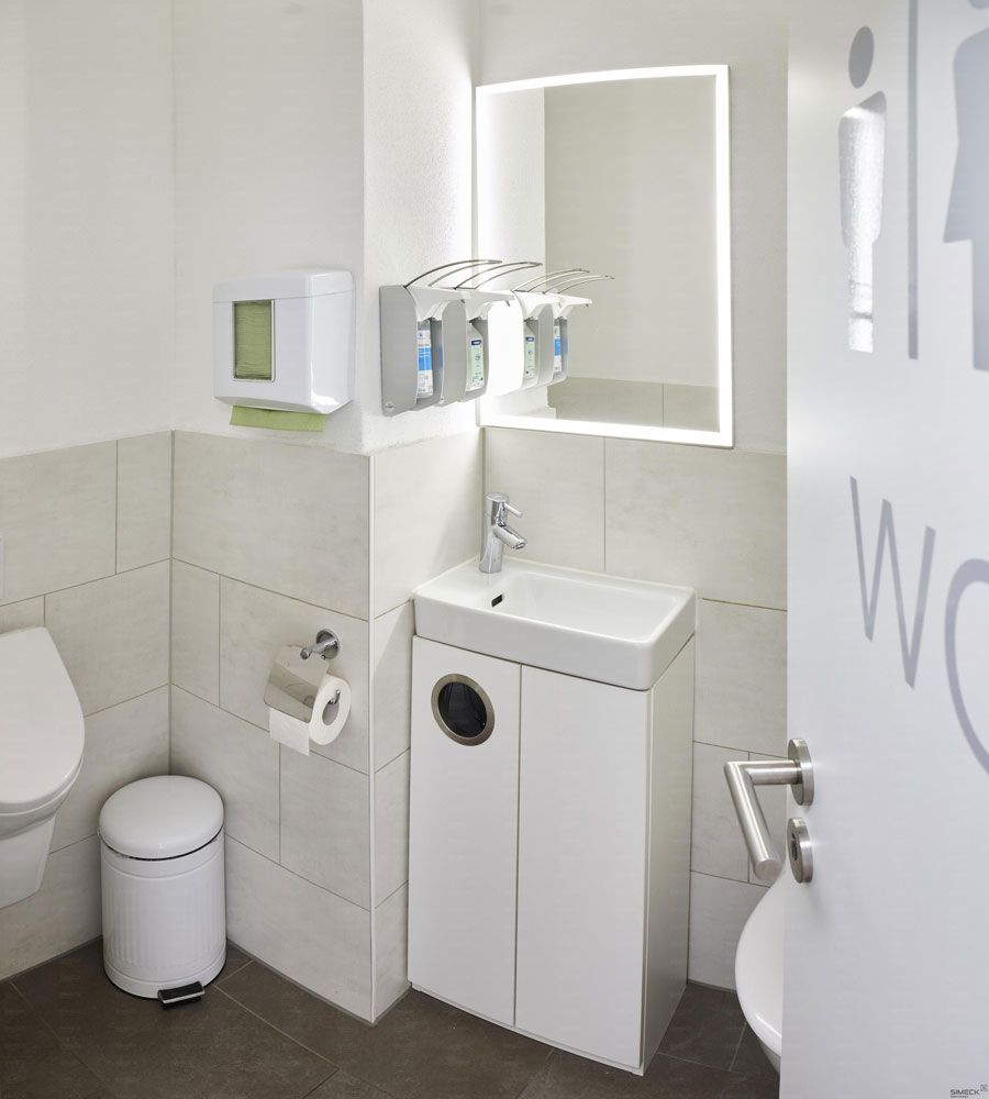 Ein Badezimmer mit Toilette, Waschbecken und Spiegel
