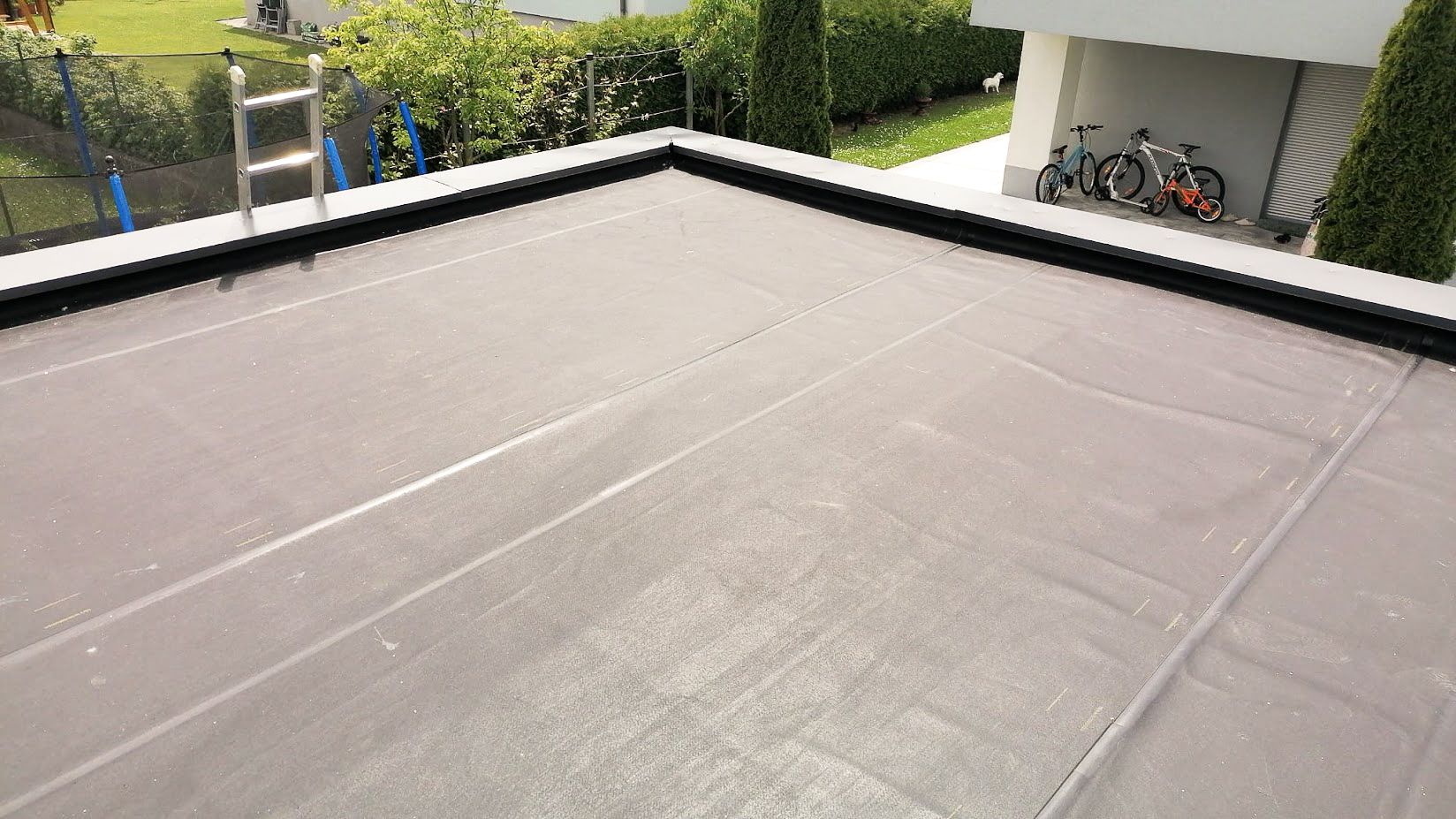 Ein Dach mit einer Leiter und darauf abgestellten Fahrrädern.