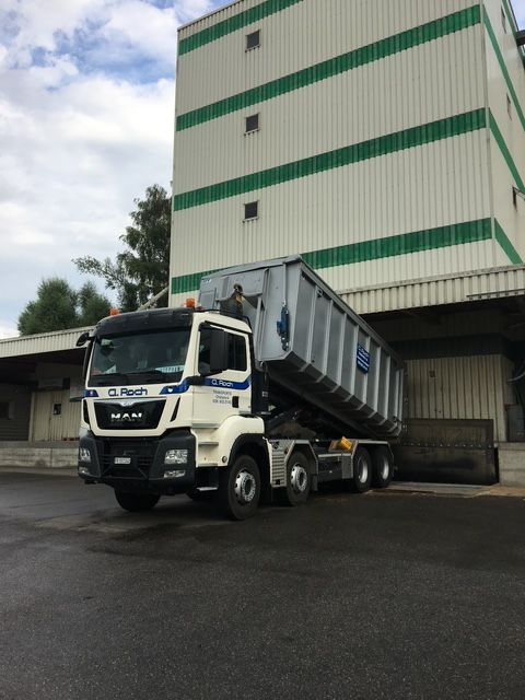 Camion blanc à côté d'un convoyeur industriel bleu et rouge ou d'un silo dans une installation de chargement