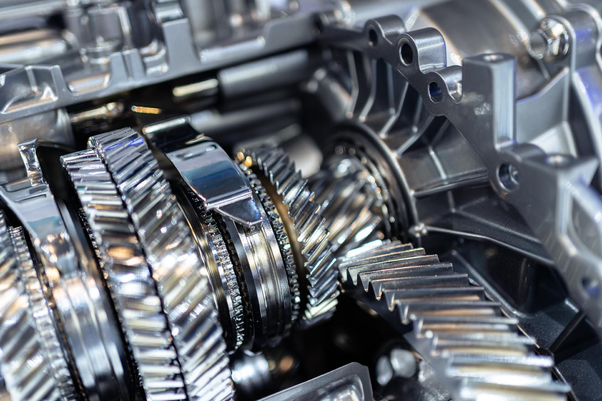 Nahaufnahme von glänzenden Metallzahnrädern und Getriebekomponenten im Inneren einer mechanischen Baugruppe