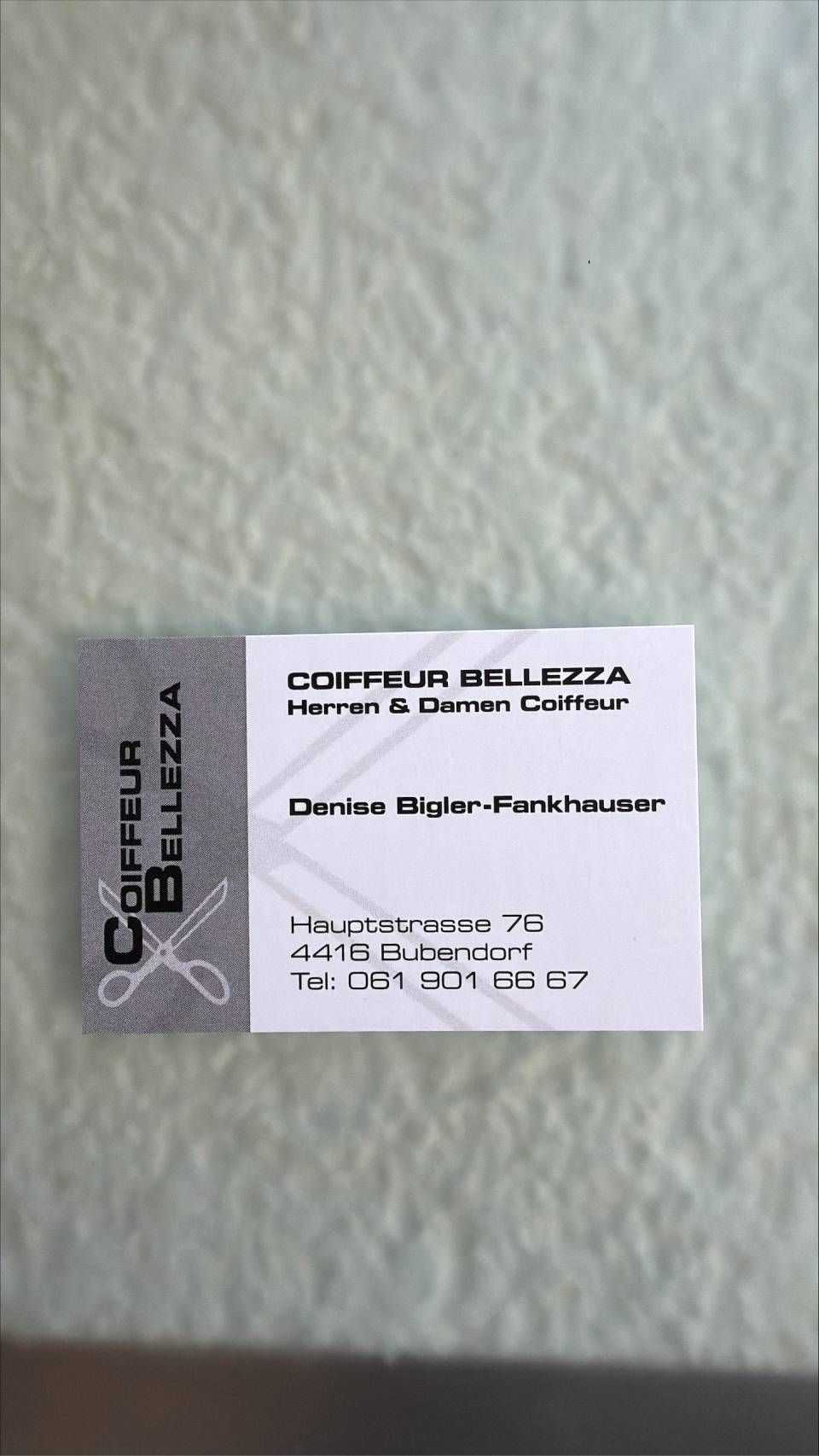 Eine Visitenkarte für Coiffeur Bellezza mit Salon-Kontaktinformationen und einem Scheren-Symbol auf weissem Hintergrund.