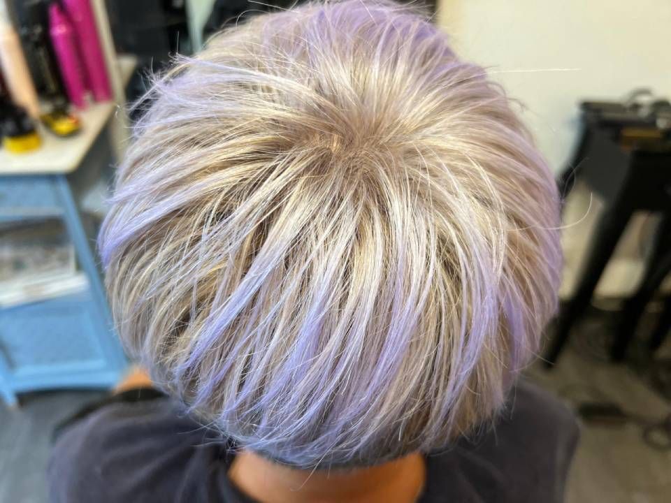 Draufsicht auf kurzes Haar mit silbernen, platinblonden und zarten lavendelfarbenen Strähnen, gestylt im Salon.
