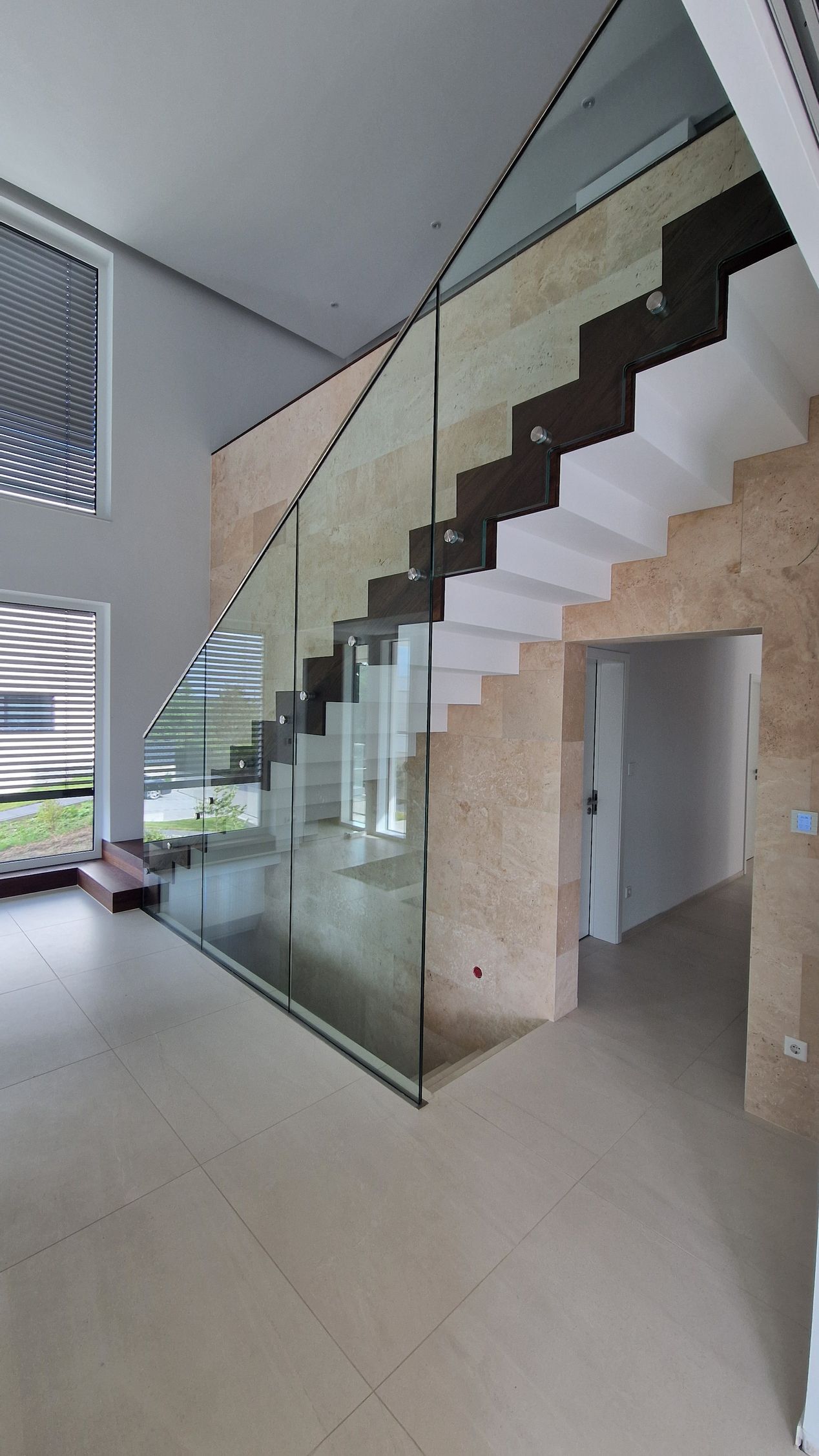 Modernes Interieur Modernes Interieur mit freitragender Treppe, Glasgeländer und strukturierter Wand. Der Raum ist lichtdurchflutet.