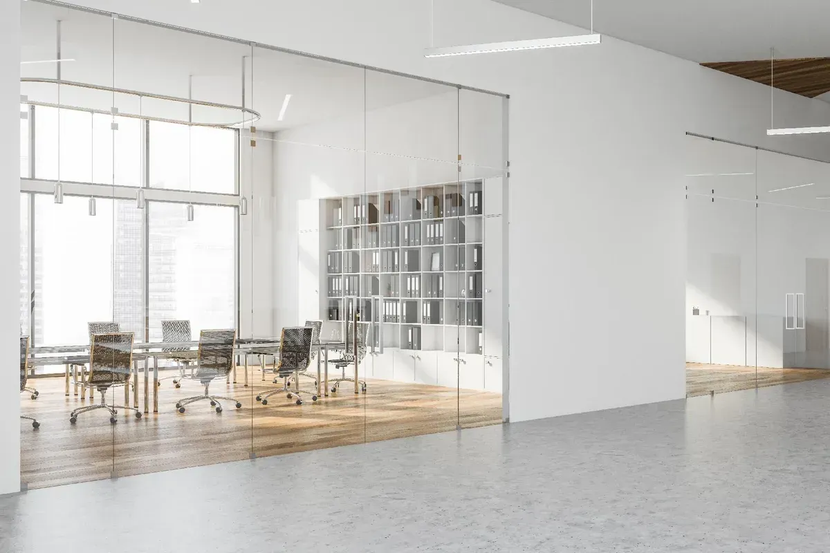 Modernes Bürointerieur mit Glaswänden, Konferenztisch und natürlichem Licht.