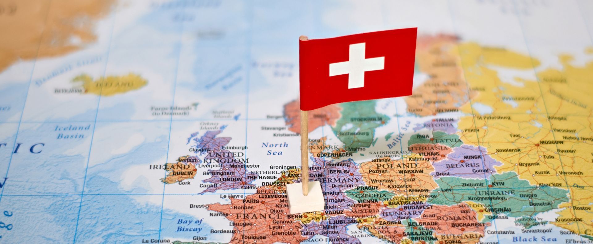 Europa auf einem Globus zusammen mit der Schweizer Flagge als Symbolbild für einen Auslandsumzug.