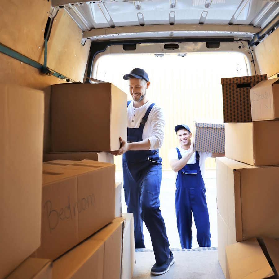 Zwei Umzugshelfer einer Umzugsfirma in Winterthur laden Kisten aus einem Umzugsauto.