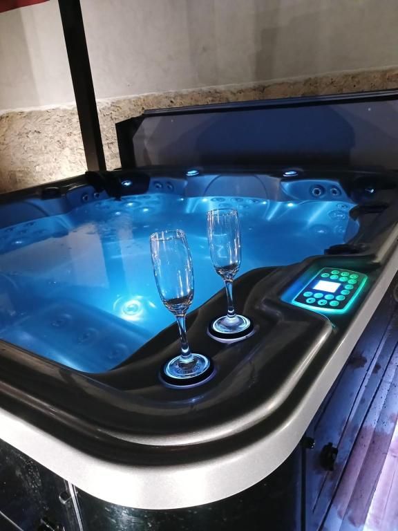Un bain à remous éclairé avec deux verres de champagne posés sur le bord.