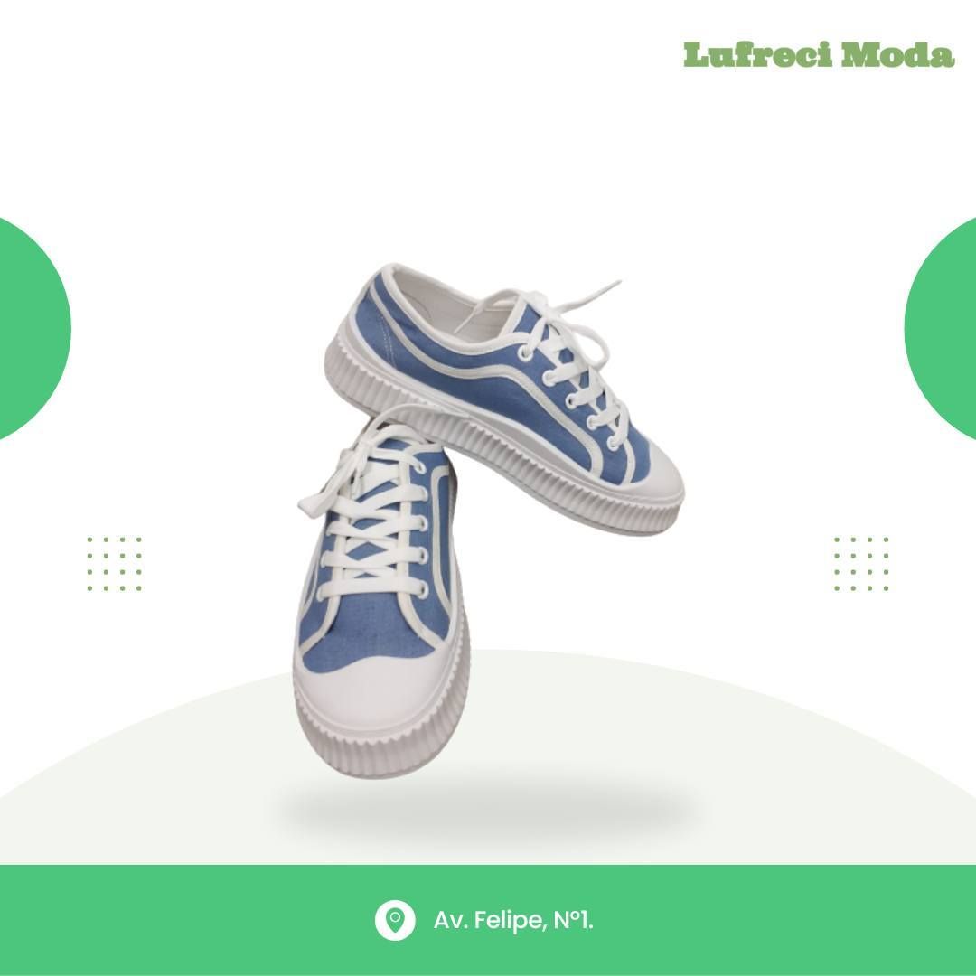 Un par de zapatillas de lona azules y blancas flotando sobre un fondo blanco con detalles verdes y texto de dirección.