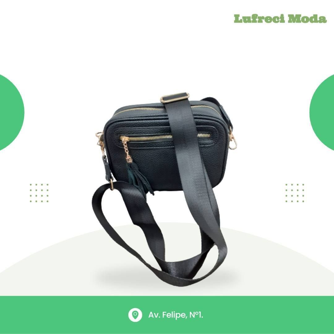 Bolso bandolera negro con cremalleras doradas y correa gruesa, centrado sobre un fondo verde claro para Lufreci Moda.