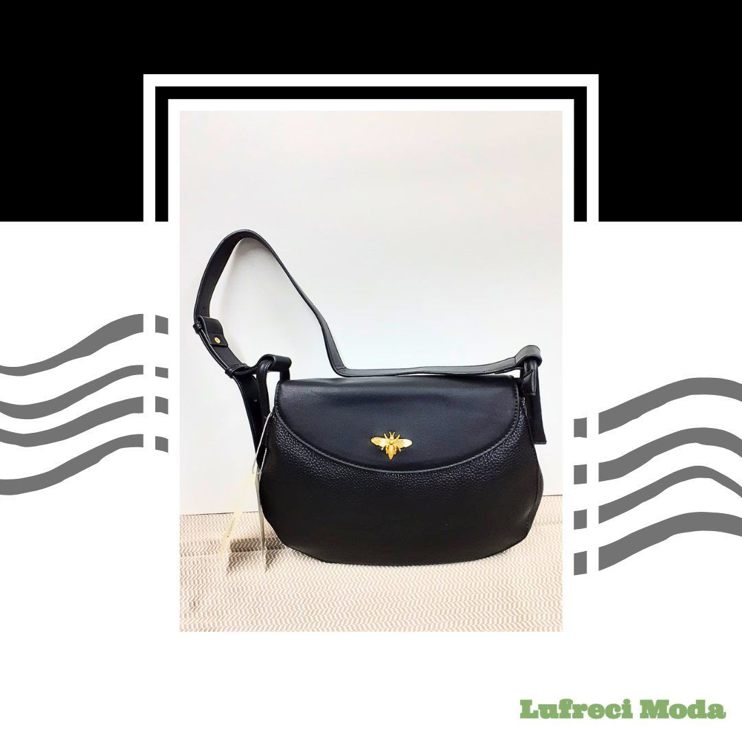 Un bolso de hombro negro que presenta un emblema de abeja dorado