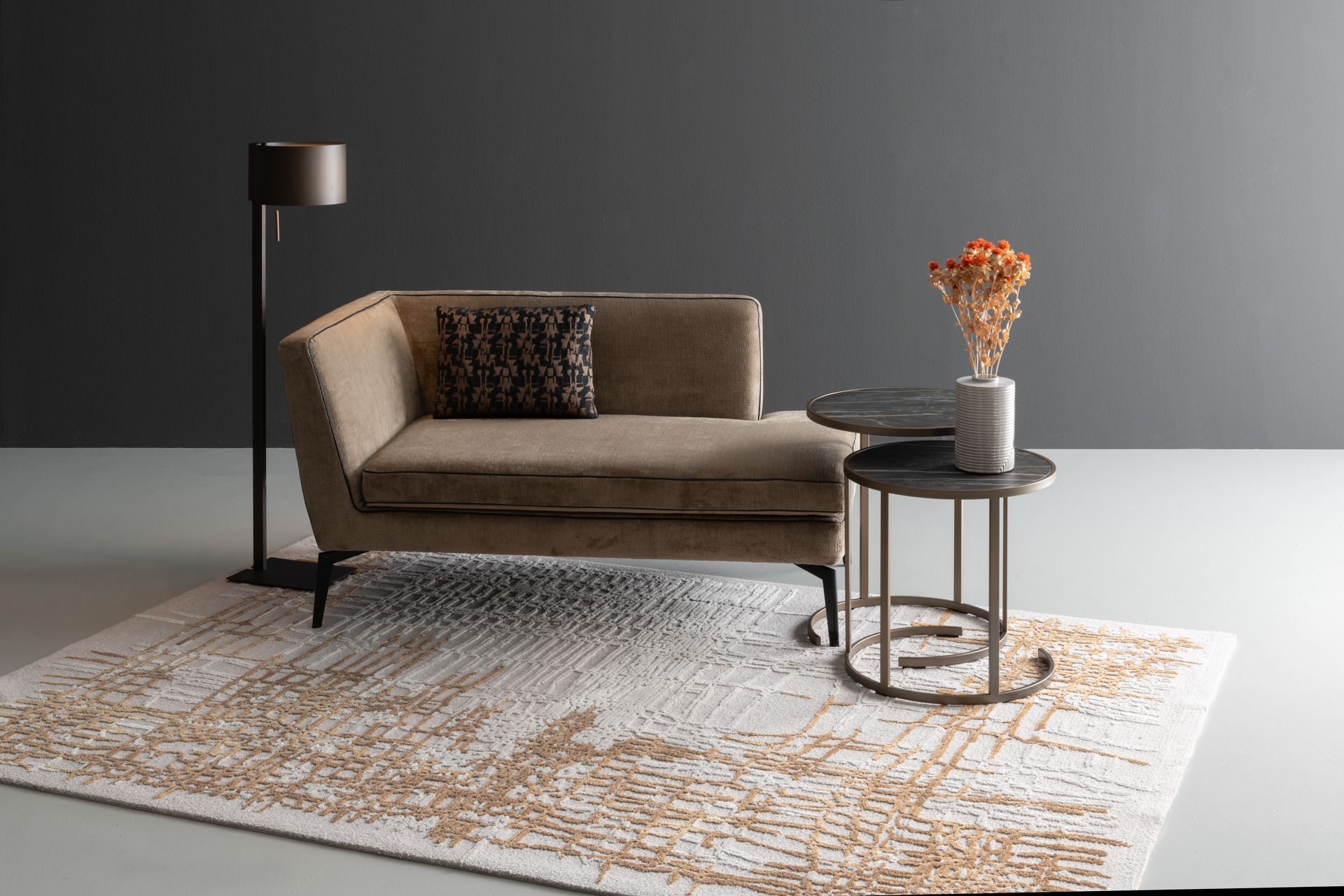 Beiges Sofa mit dekorativem Kissen, Stehlampe, zwei Beistelltischen mit Vase und gemustertem Teppich.