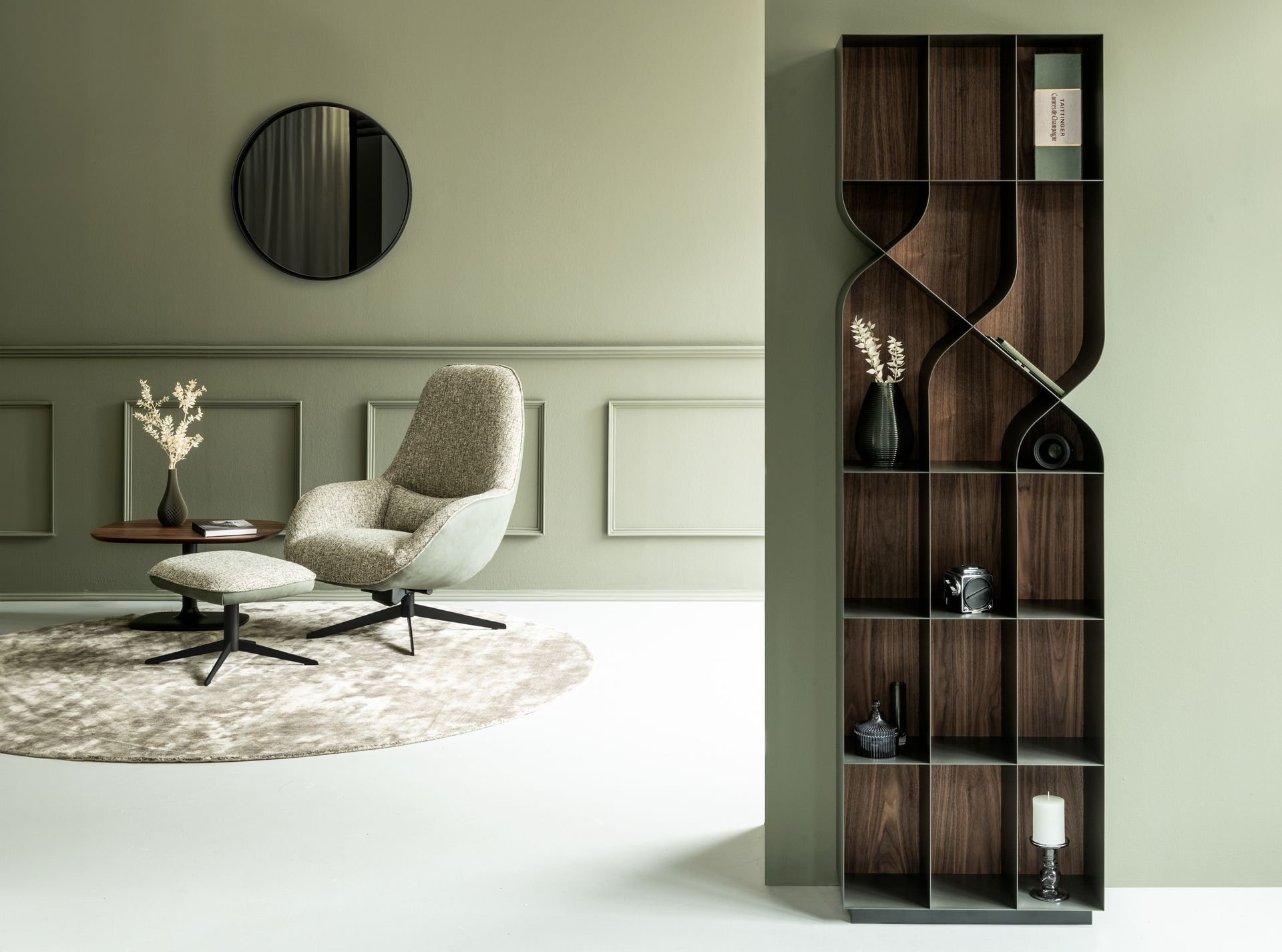 Modernes Wohnzimmer mit olivfarbenen Wänden, einem geschwungenen Bücherregal und einem gemütlichen Sessel.