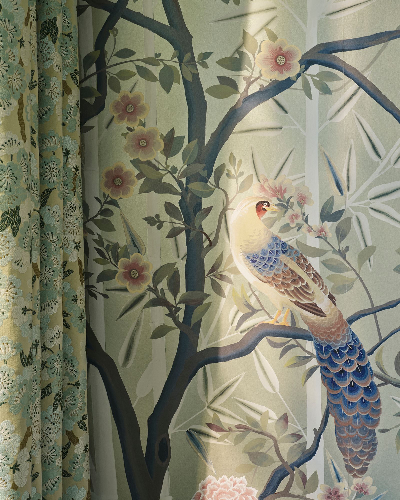 Vogel auf einem Ast, Blumentapete in Grün, Rosa und Braun. Vorhänge links.