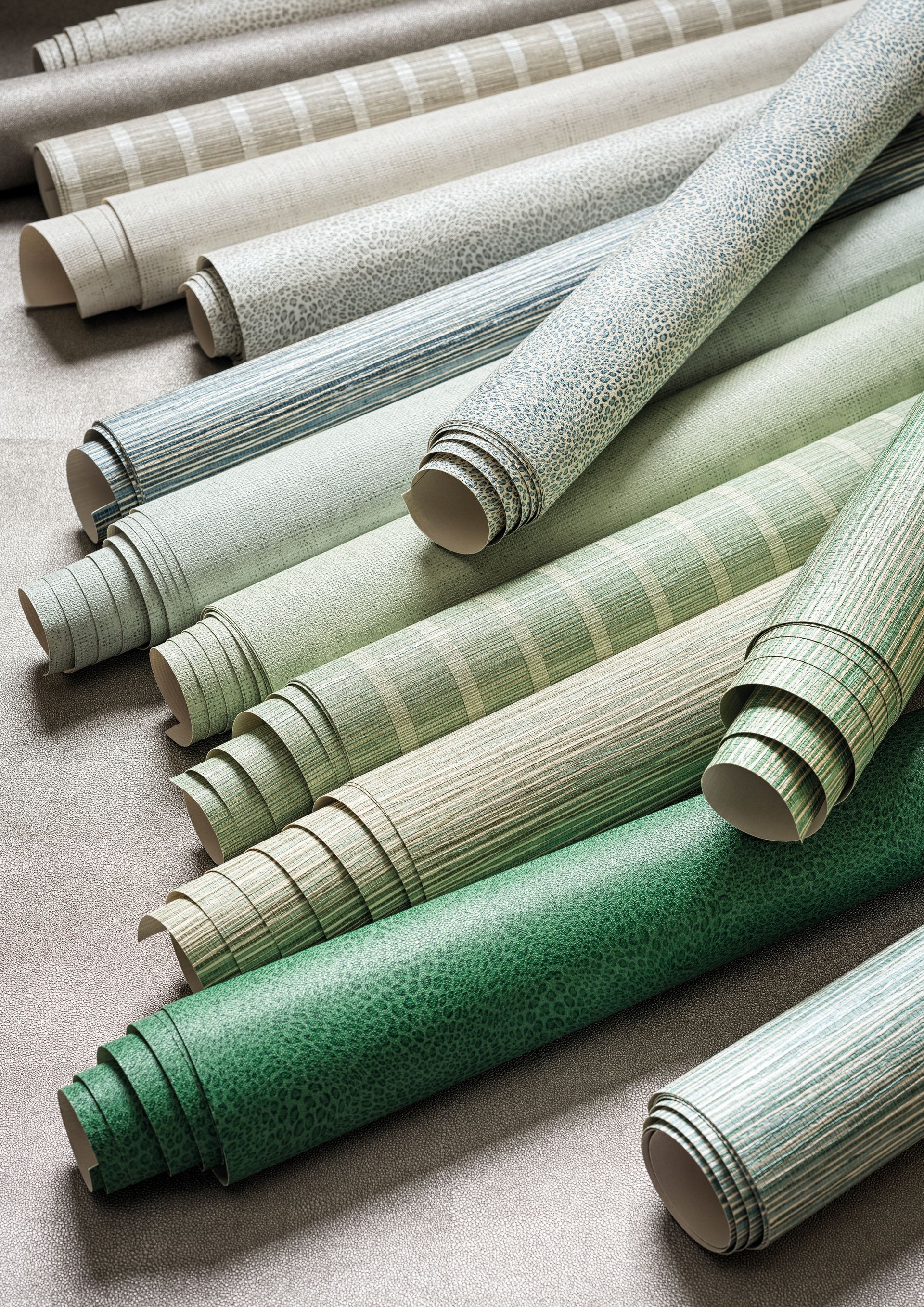Rollen mit strukturierter Tapete in Grüntönen und neutralen Tönen, präsentiert auf einer strukturierten Oberfläche.
