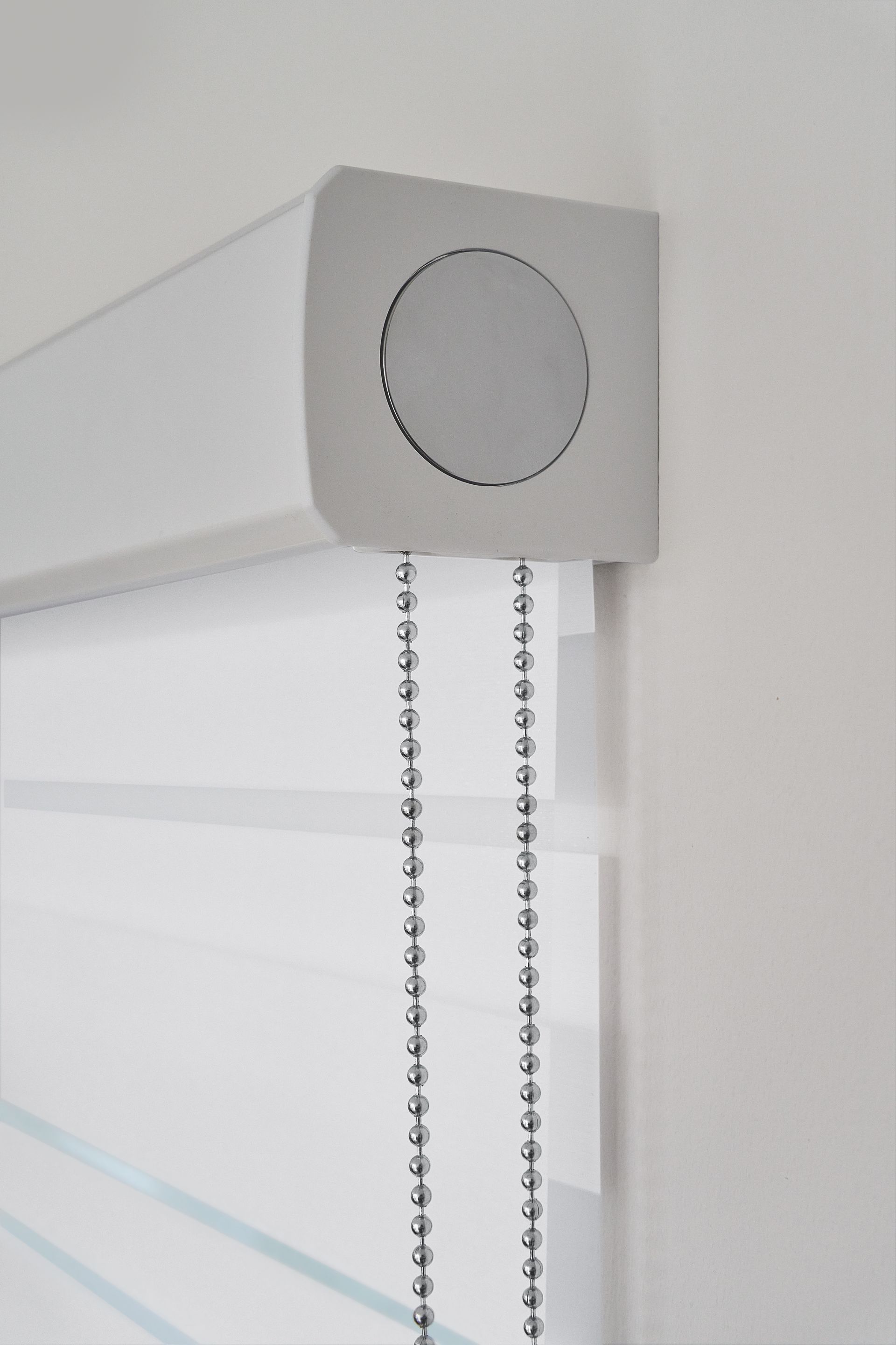 Weiße Zebra-Rollos mit Kettenzugmechanismus; Nahaufnahme.