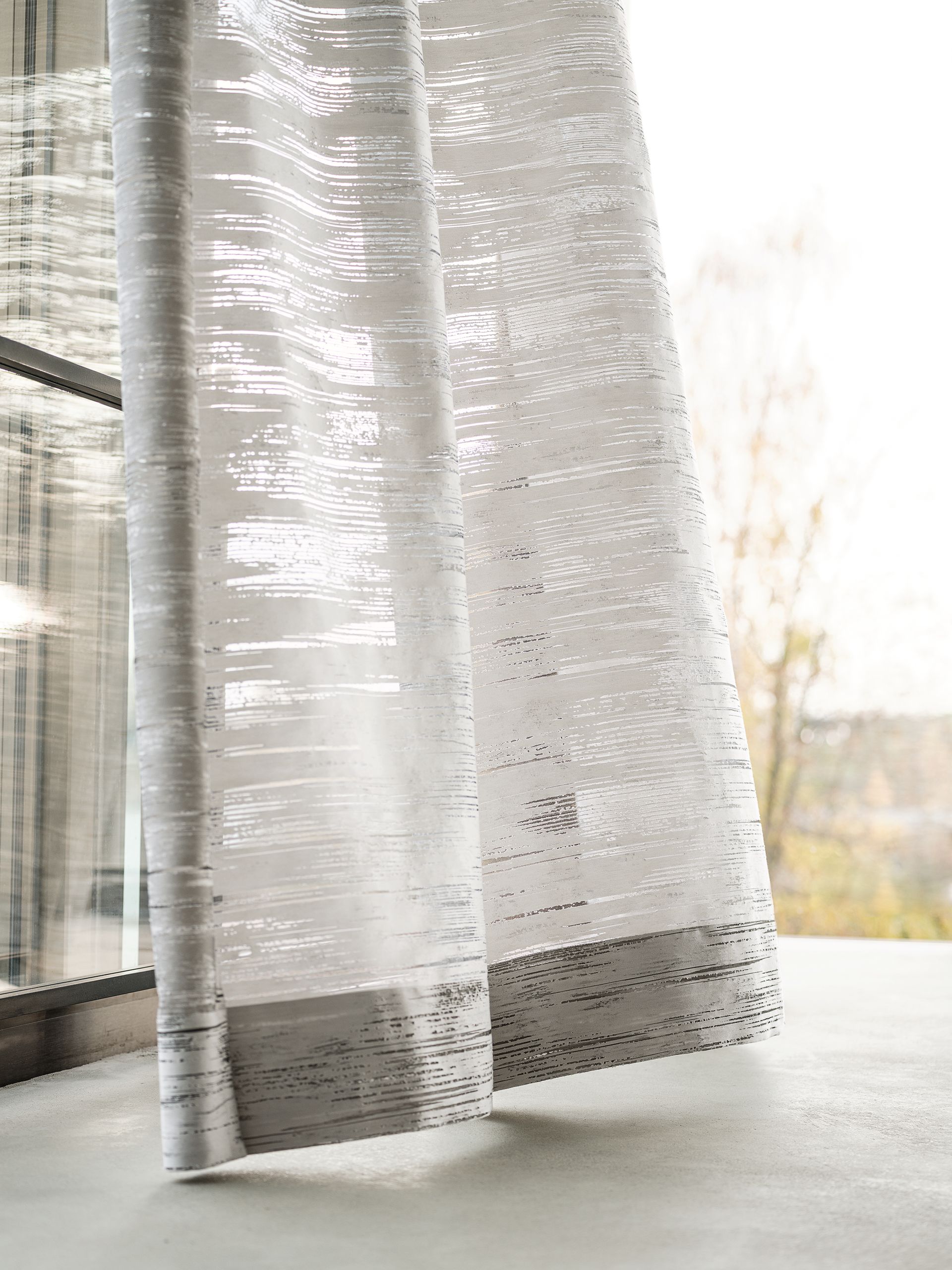 Transparente weiße Vorhänge wehen in der Nähe eines Fensters.