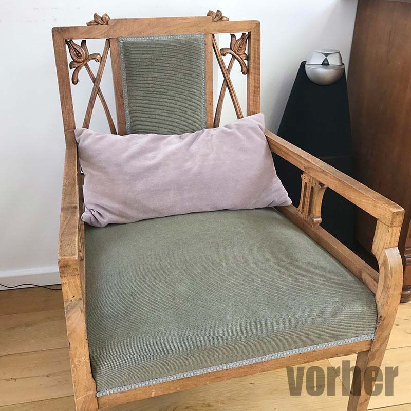 Holzsessel mit grünem Stoff und malvenfarbenem Kissen.