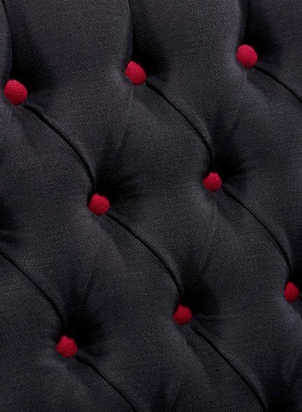Schwarze Polsterung mit roten getufteten Knöpfen.