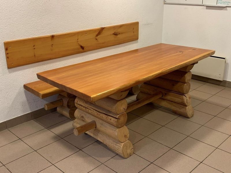 Une table en bois avec un banc attaché dans une pièce.