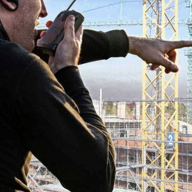 TWO EYES SECURITY GmbH Person mit Tablet in der Hand überwacht eine Baustelle