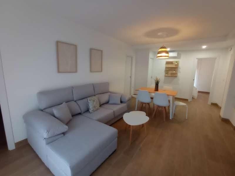 Una sala de estar con un sofá, una mesa y sillas.