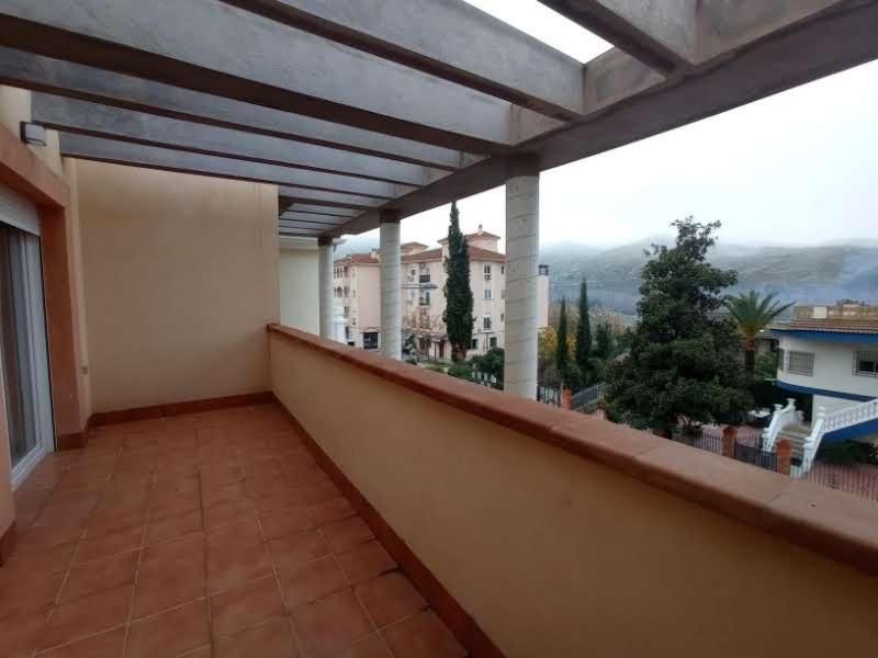 Un balcón con vista a edificios y árboles.