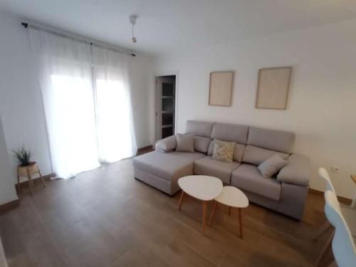 Una sala de estar con un sofá y dos mesas de café.