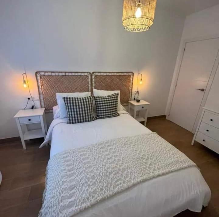 Un dormitorio con una cama y dos mesitas de noche.