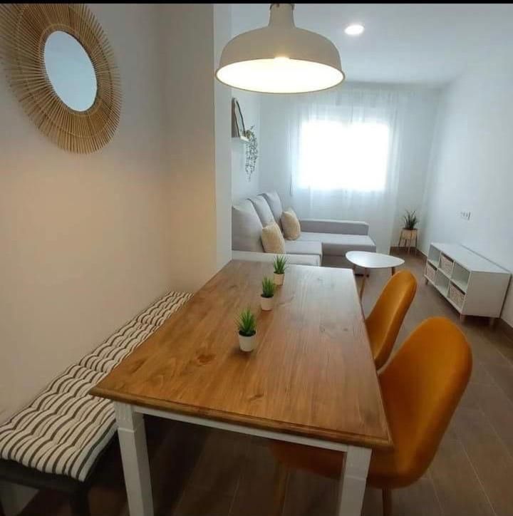 Una sala de estar con una mesa y sillas de madera.
