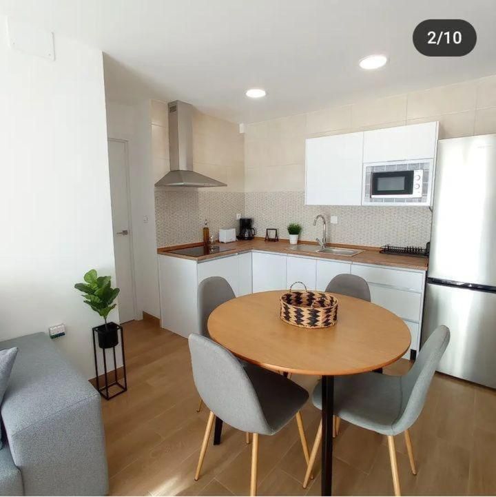 Una cocina con mesa y sillas y el número 2/10