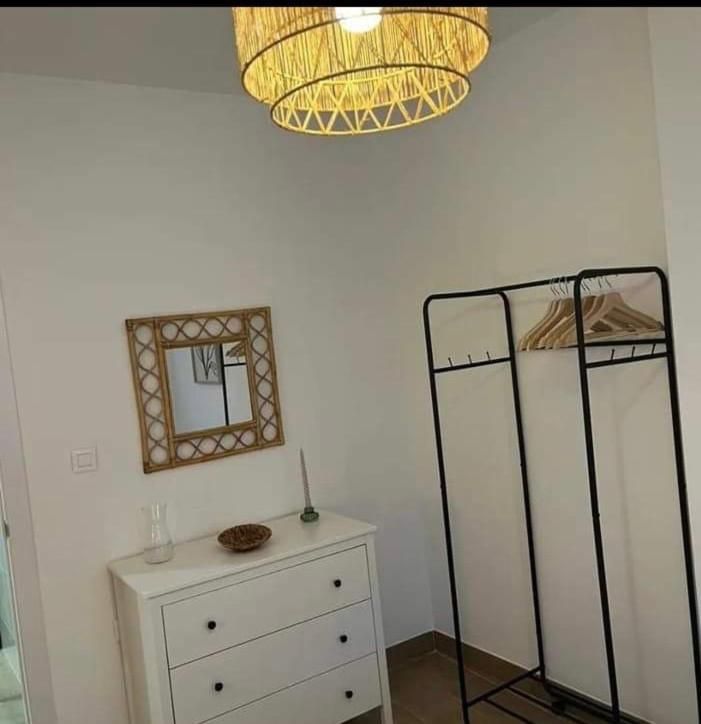 Una habitación con una cómoda, un espejo y un perchero.