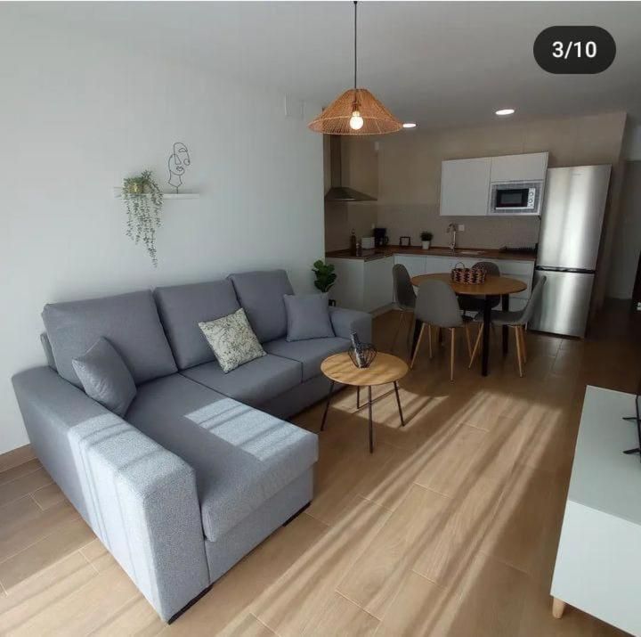 Una sala de estar con un sofá seccional gris y una mesa.