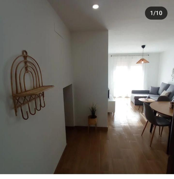 Una imagen de una sala de estar con una jaula de pájaros en la pared.