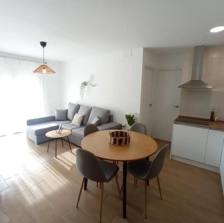 Una sala de estar con una mesa y sillas y un sofá.