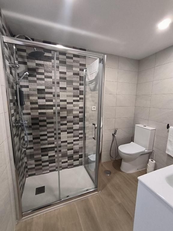 Un baño con inodoro, ducha y lavabo.
