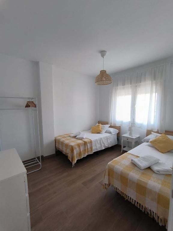 Un dormitorio con dos camas y una cómoda.