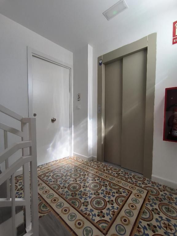 Un pasillo con escalera y ascensor.