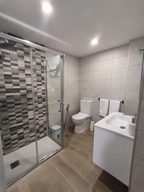 Un baño con inodoro, lavabo, ducha y plato de ducha.