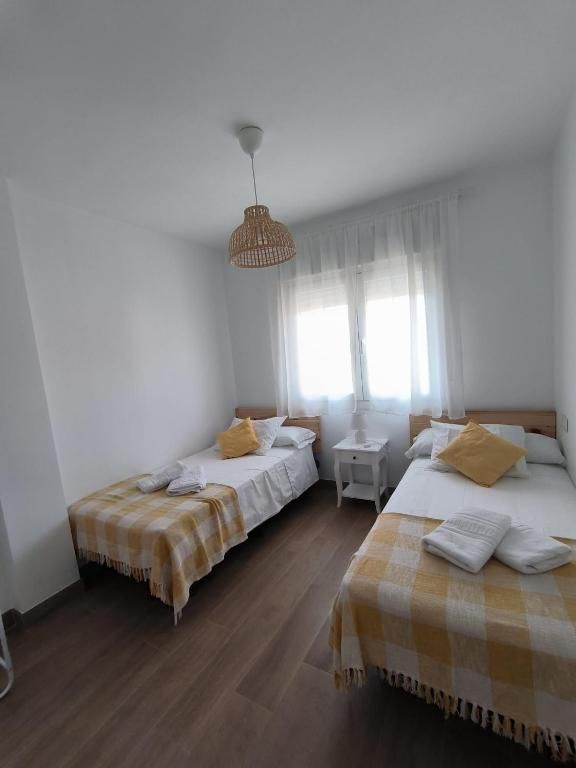 Un dormitorio con dos camas y una mesita de noche.