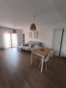 Una sala de estar con sofá, mesa y sillas.