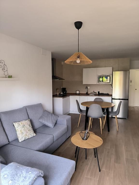 Una sala de estar con un sofá, una mesa y sillas.