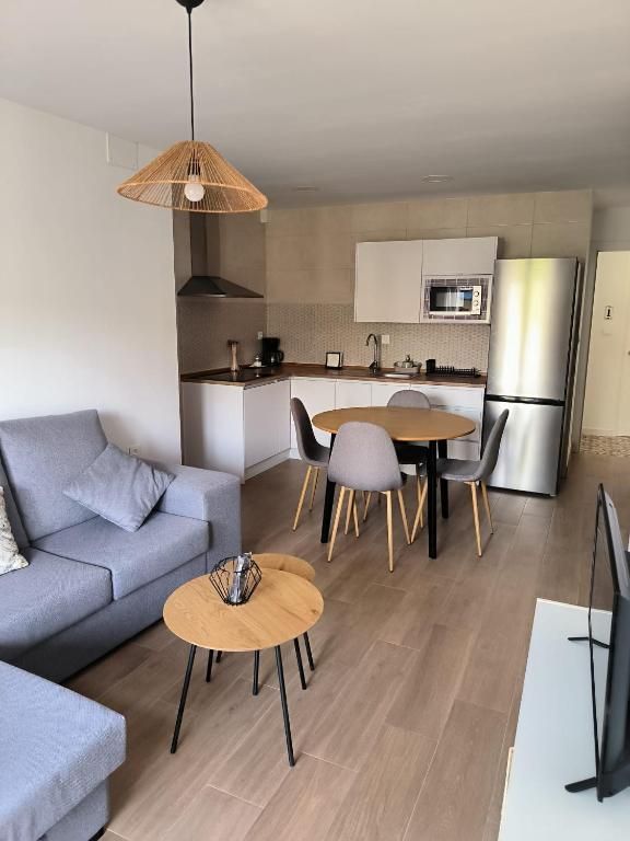 Una sala de estar con un sofá, una mesa y sillas.