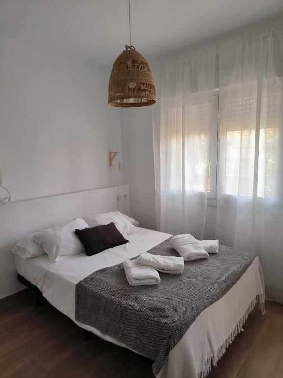 Un dormitorio con una cama grande y una lámpara colgando del techo.