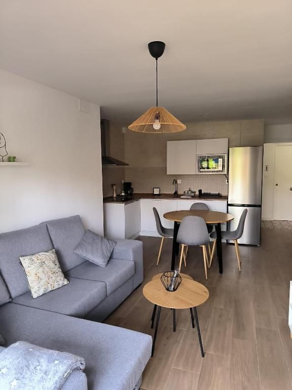 Una sala de estar con un sofá, una mesa y sillas.
